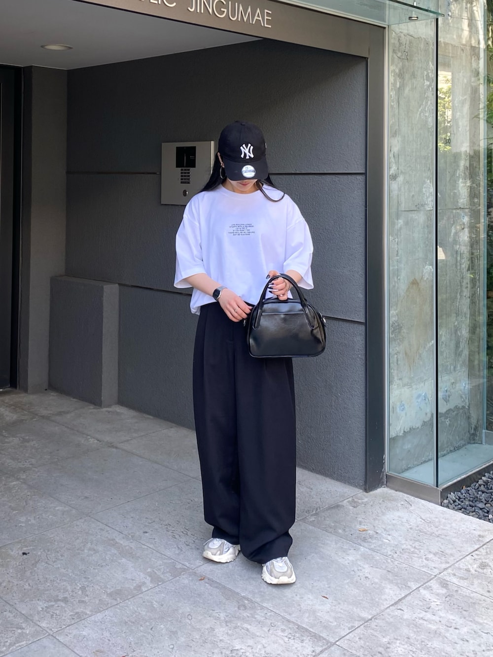 ホワイト系のTシャツ/カットソー、ブラック系のスラックス、ブラック系のボストンバッグを着用したレディースの春コーディネートの5枚目の写真