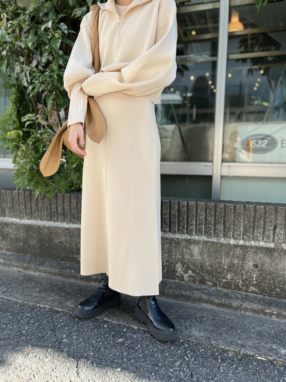 ブラック系のブーツ、ベージュ系のトートバッグ、ベージュ系のワンピースを着用したレディースの冬コーディネートの2枚目の写真