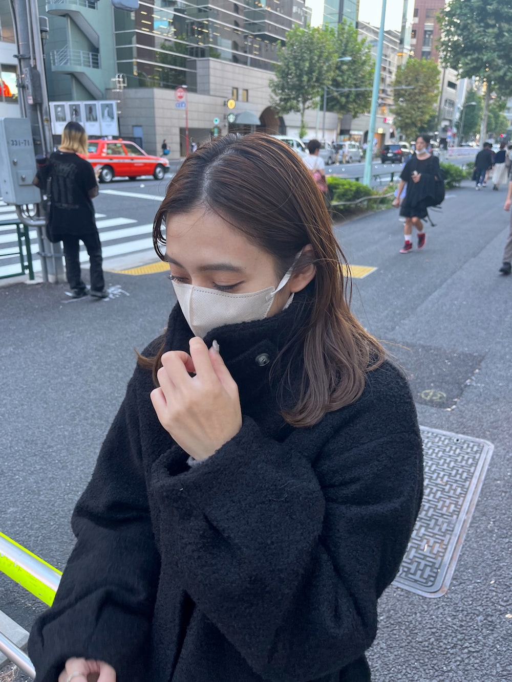 ブラック系のステンカラーコートを着用したレディースの秋コーディネートの2枚目の写真