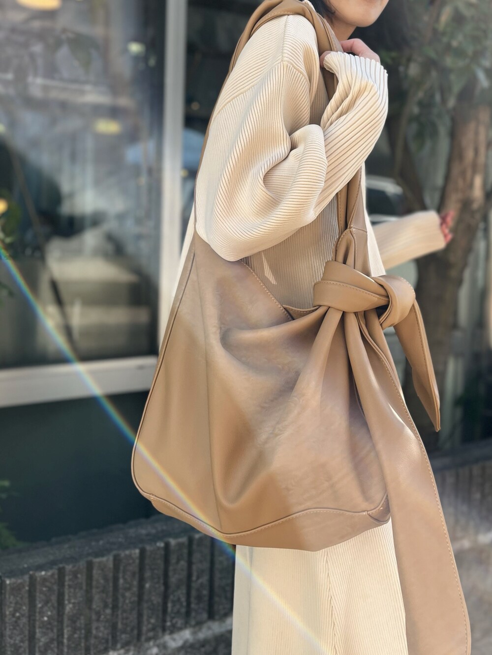 ブラック系のブーツ、ベージュ系のトートバッグ、ベージュ系のワンピースを着用したレディースの冬コーディネートの3枚目の写真