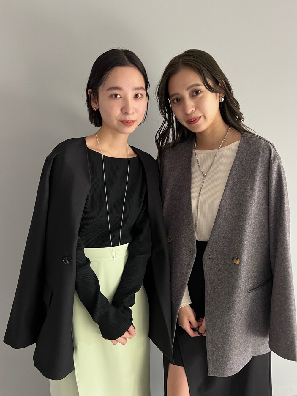 ブラック系のスカート、ブラック系のノーカラージャケット、ホワイト系のニット/セーターを着用したレディースの冬コーディネートの2枚目の写真