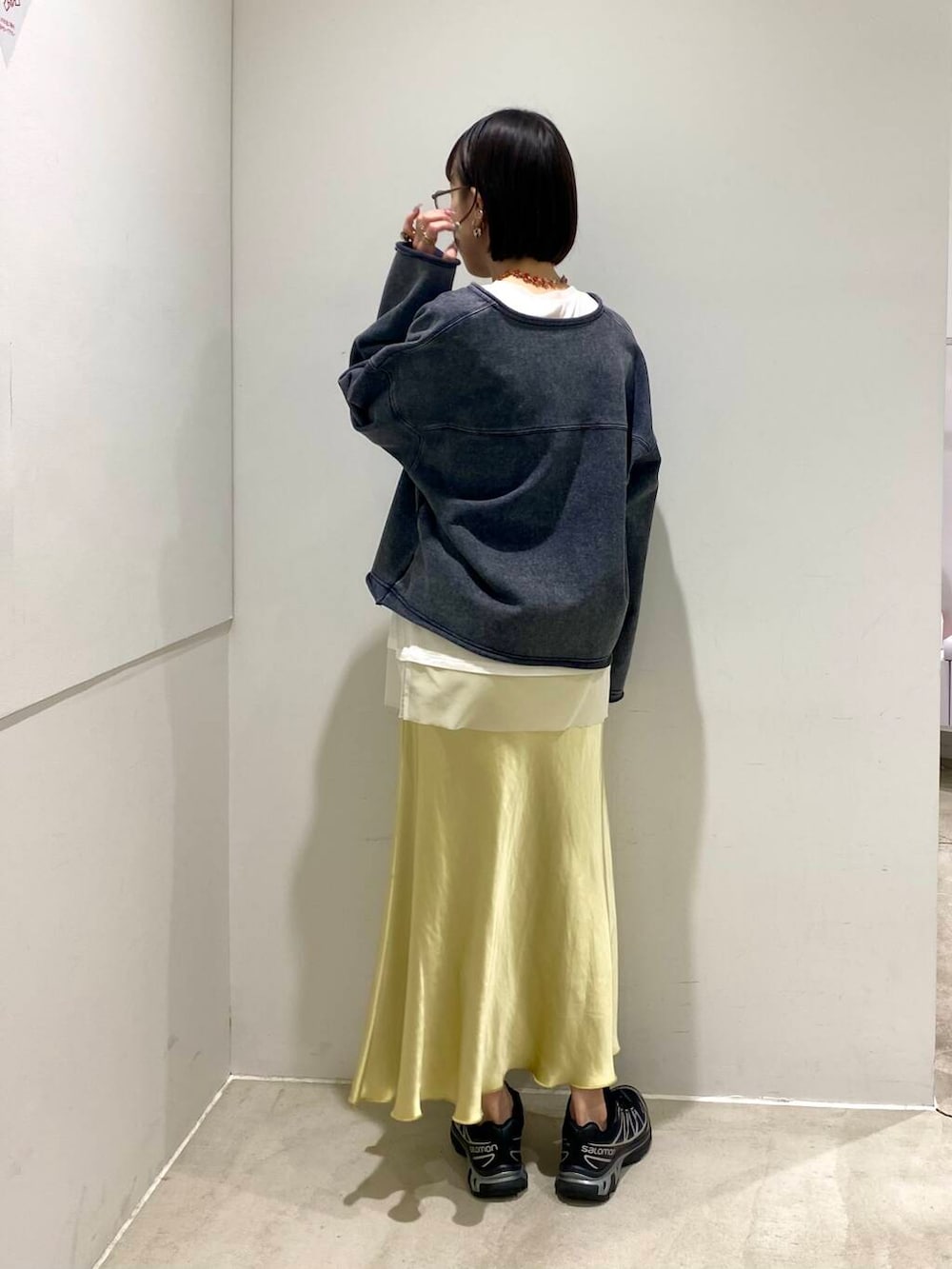 ホワイト系のTシャツ/カットソー、イエロー系のスカート、ブラック系のハンドバッグを着用したレディースの春コーディネートの2枚目の写真