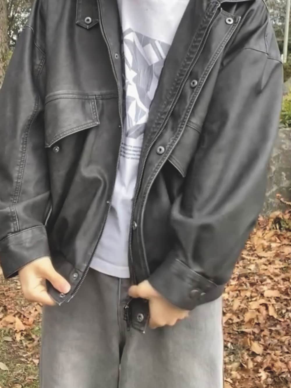 ブラック系のブルゾン、ホワイト系のTシャツ/カットソー、グレー系のデニムパンツを着用したメンズの秋コーディネートの2枚目の写真