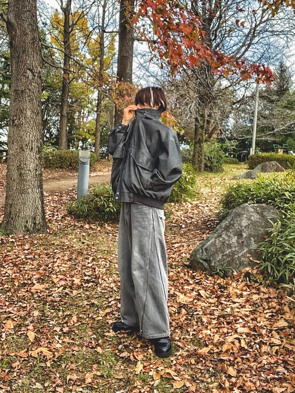 ブラック系のブルゾン、ホワイト系のTシャツ/カットソー、グレー系のデニムパンツを着用したメンズの秋コーディネートの4枚目の写真