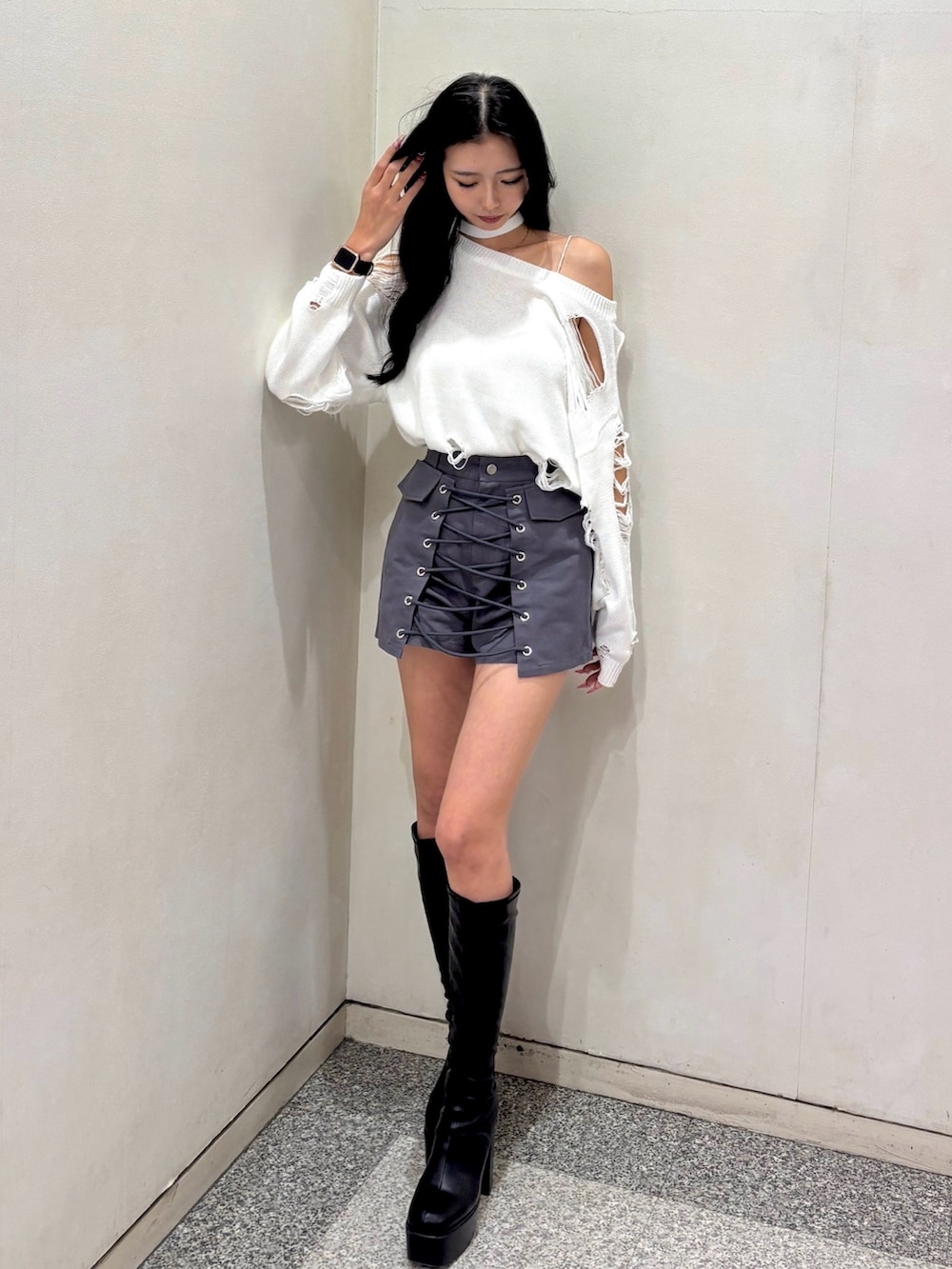 ホワイト系のニット/セーター、グレー系のスカート、ブラック系のブーツを着用したレディースの冬コーディネートの2枚目の写真