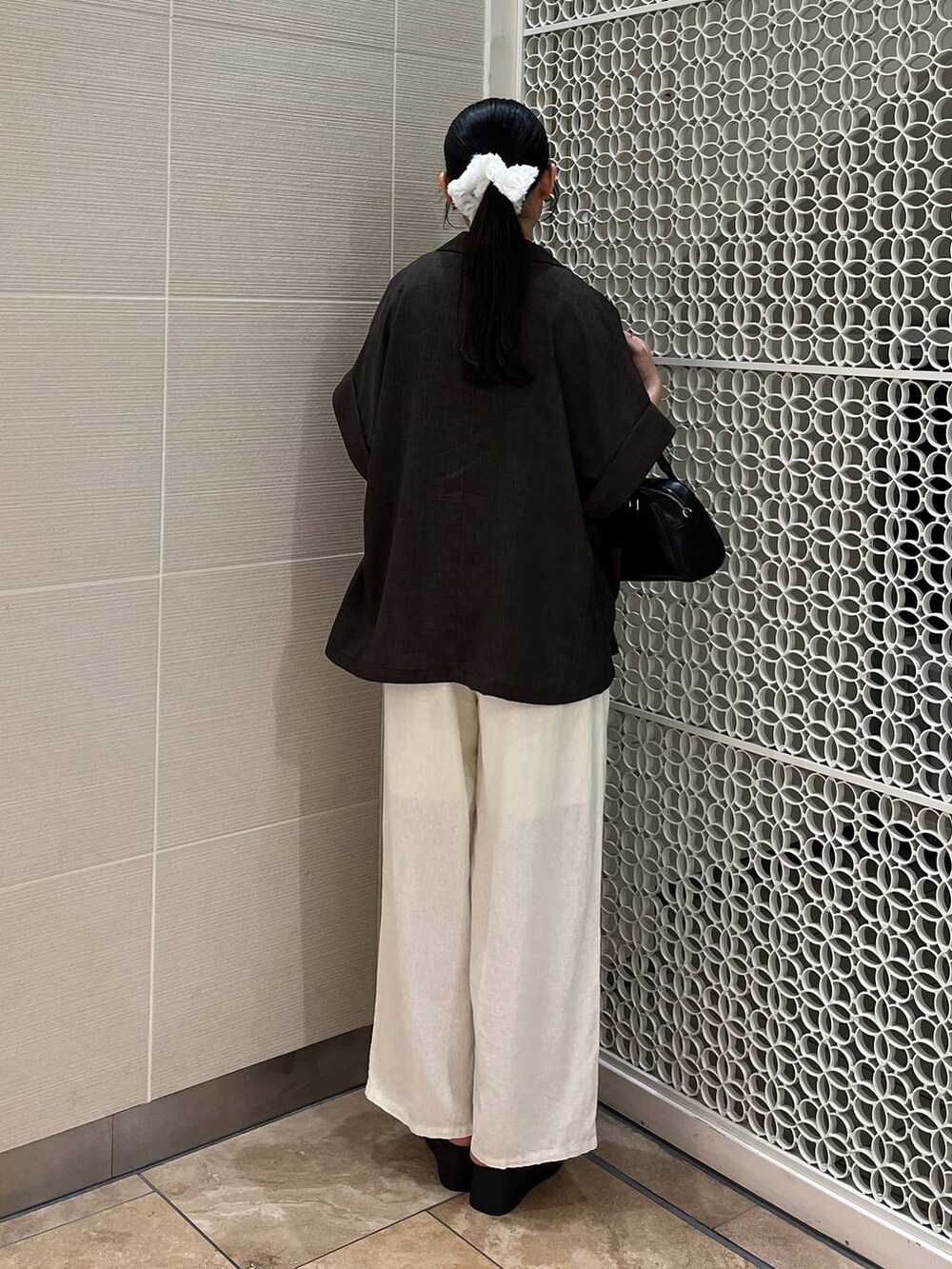 ベージュ系のその他パンツ、ホワイト系のタンクトップ、ブラック系のサンダルを着用したレディースの夏コーディネートの2枚目の写真