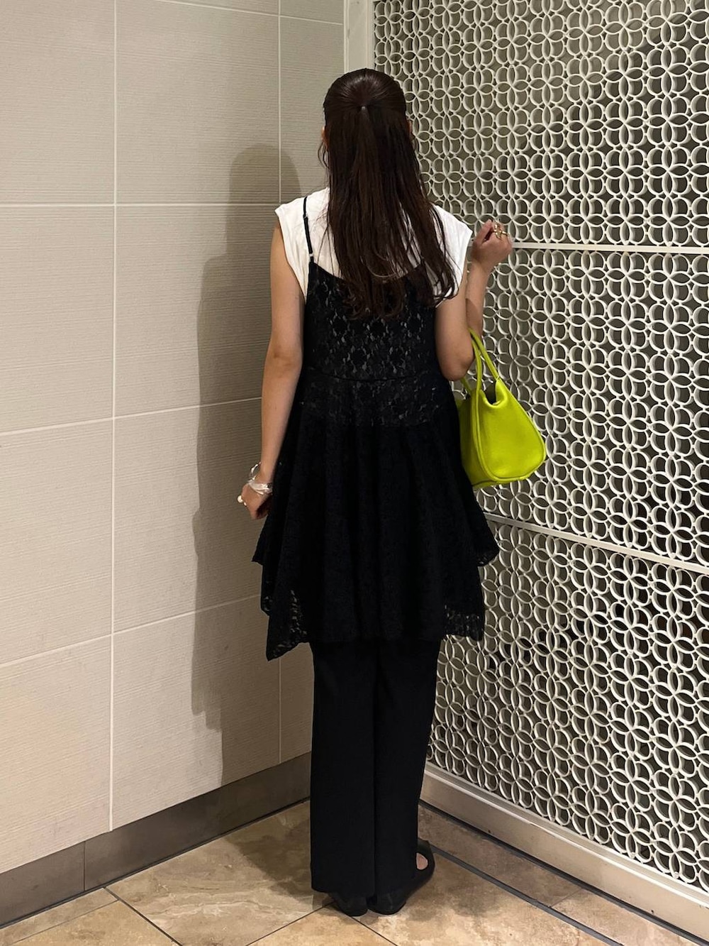 ブラック系のデニムパンツ、グリーン系のショルダーバッグ、ホワイト系のTシャツ/カットソーを着用したレディースの秋コーディネートの2枚目の写真