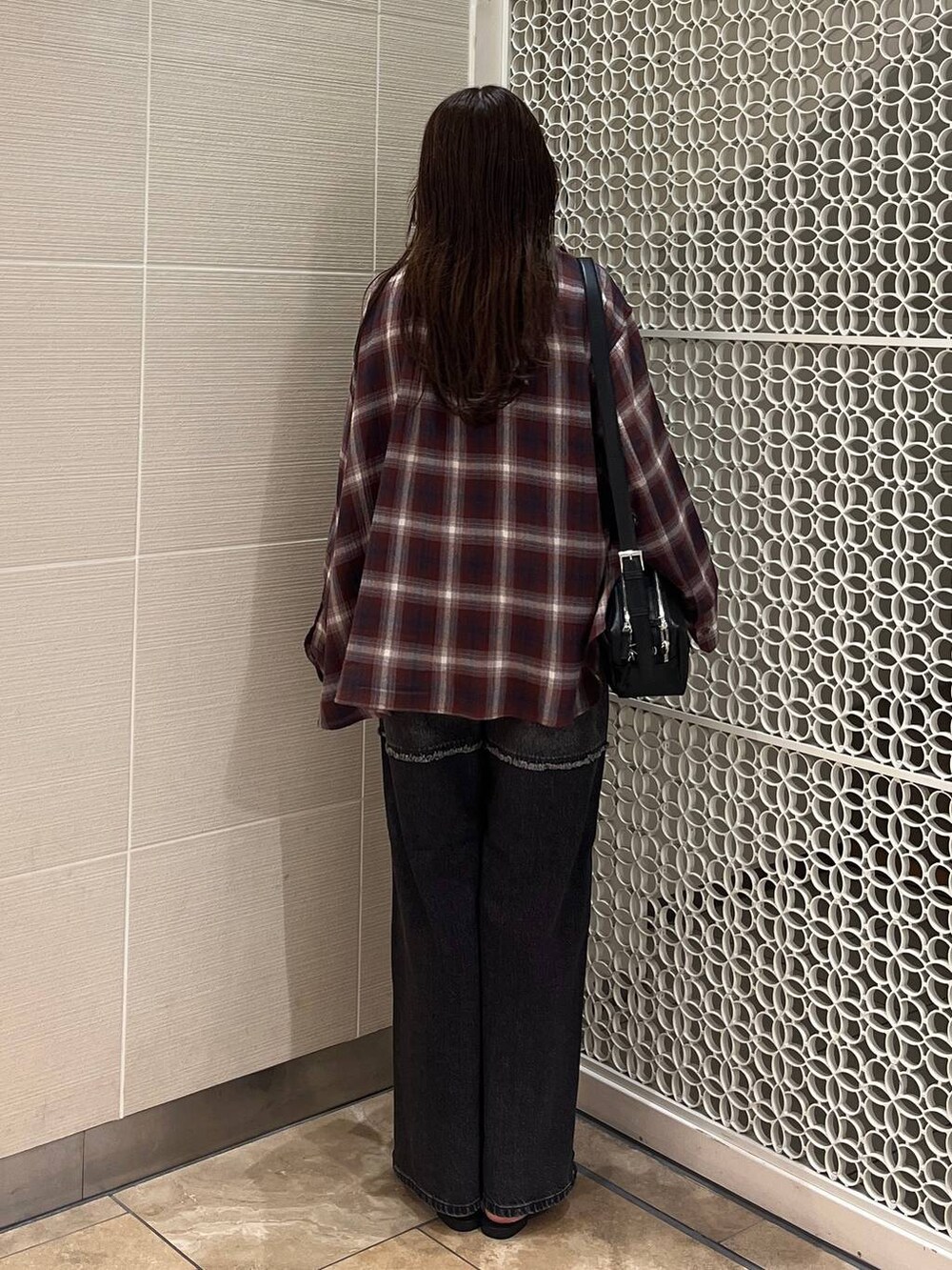 ブラック系のサンダル、ブラック系のデニムパンツ、レッド系のキャミソールを着用したレディースの秋コーディネートの3枚目の写真