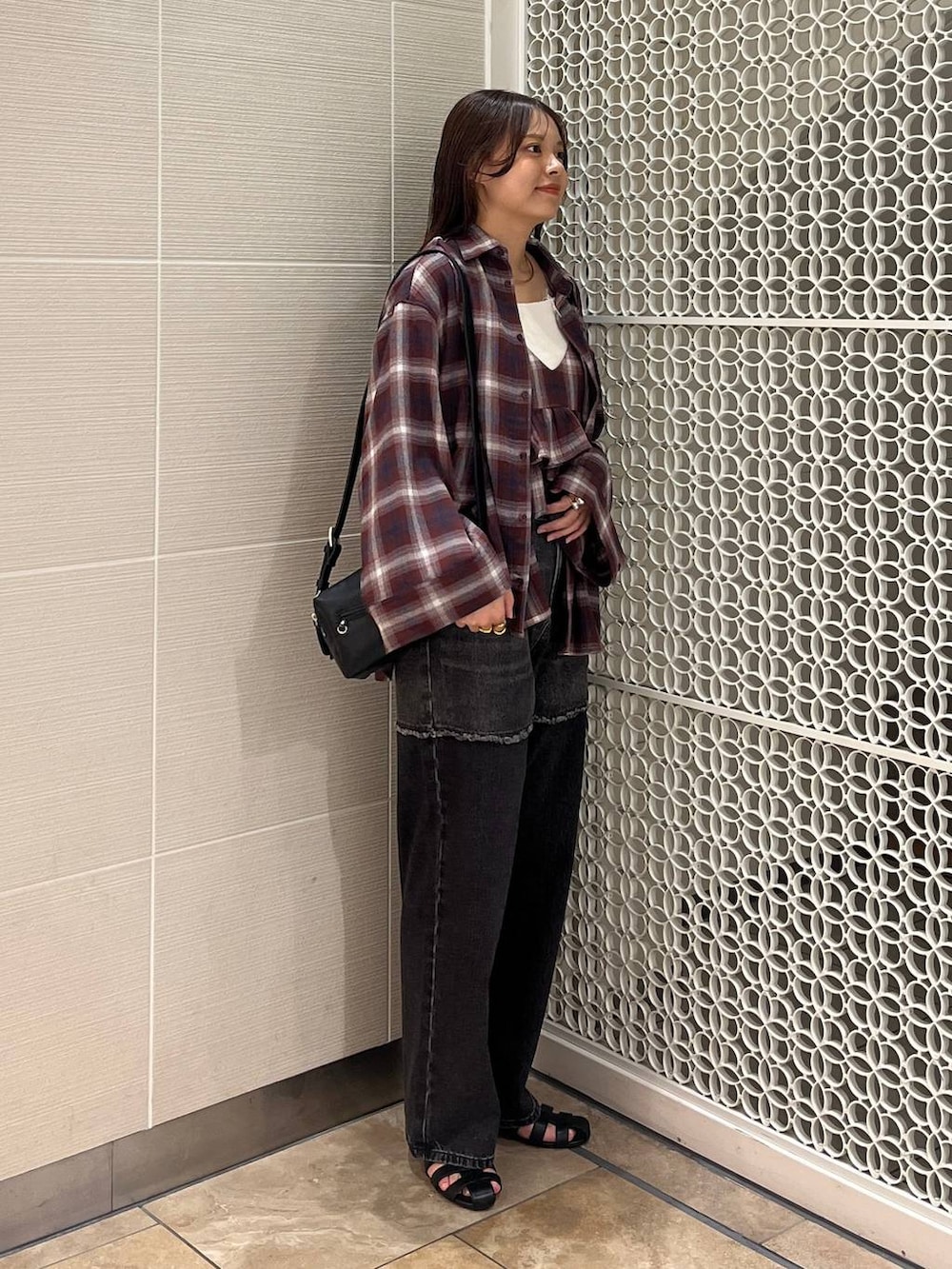 ブラック系のサンダル、ブラック系のデニムパンツ、レッド系のキャミソールを着用したレディースの秋コーディネートの2枚目の写真