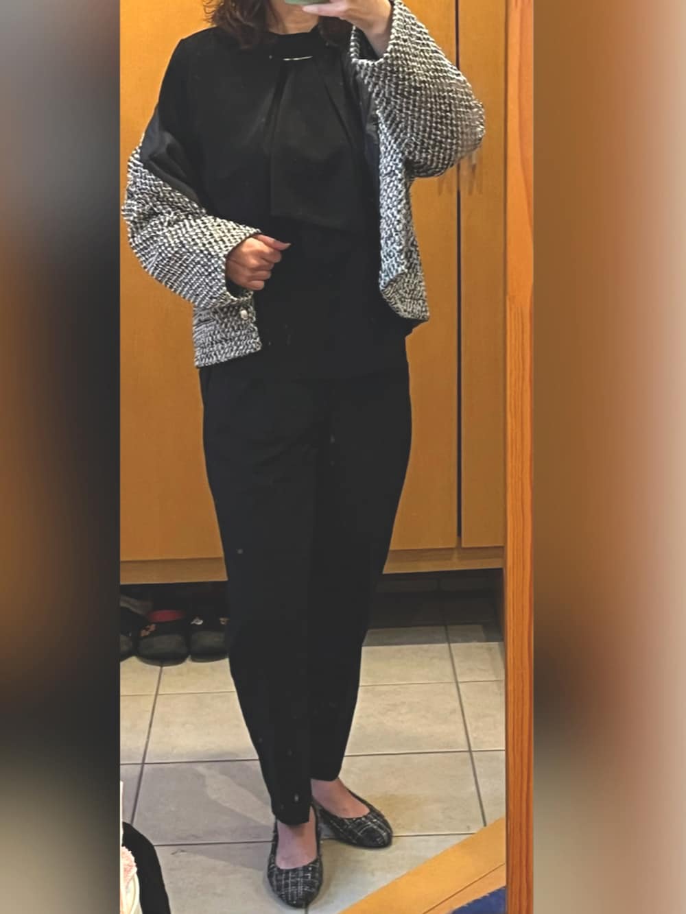 グレー系のノーカラージャケット、ブラック系のシャツ/ブラウス、ブラック系のスラックスを着用したレディースの冬コーディネートの2枚目の写真