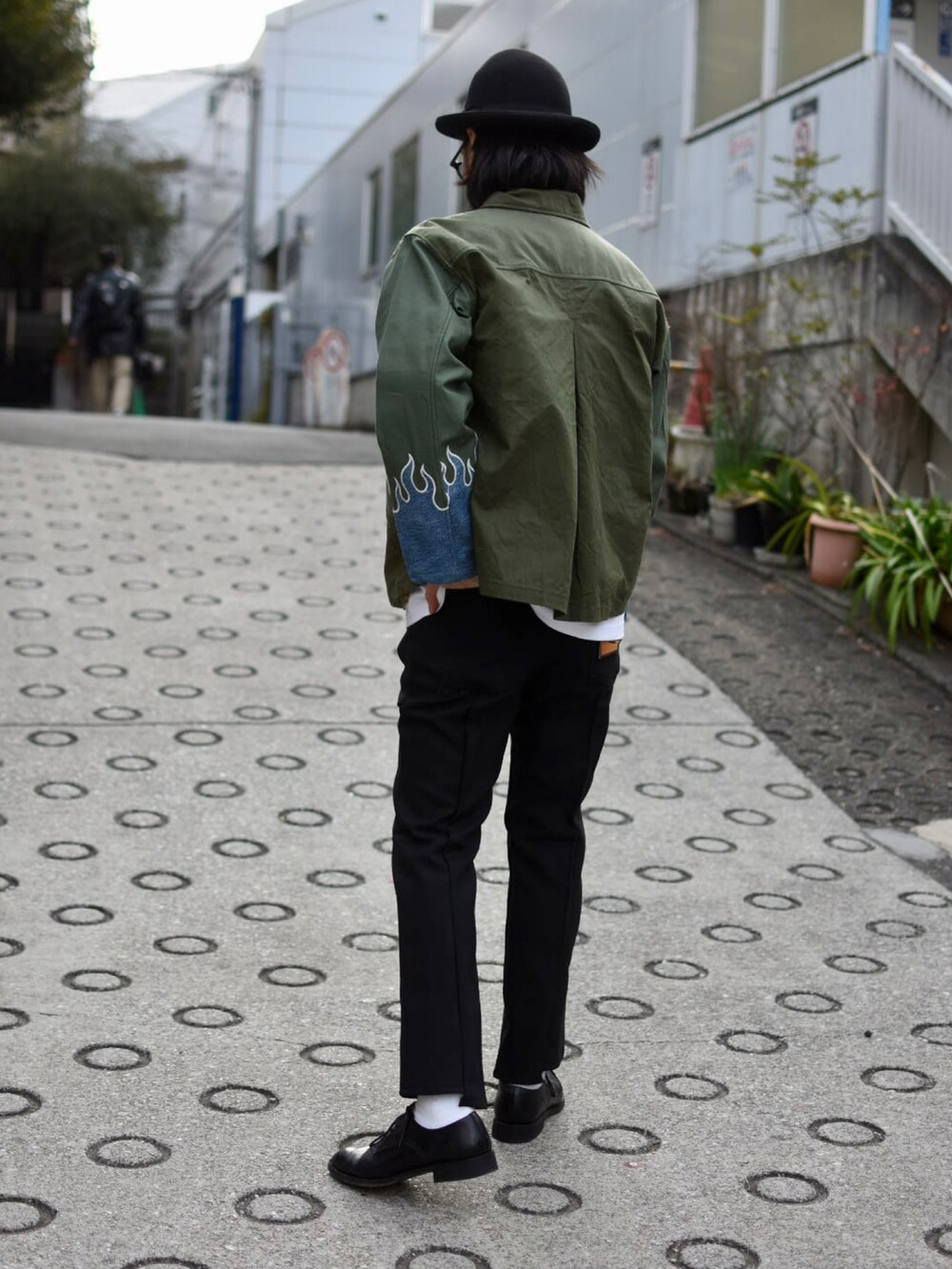 ブラック系のスラックス、グリーン系のミリタリージャケット、ブラック系のその他シューズを着用したメンズの春コーディネートの5枚目の写真