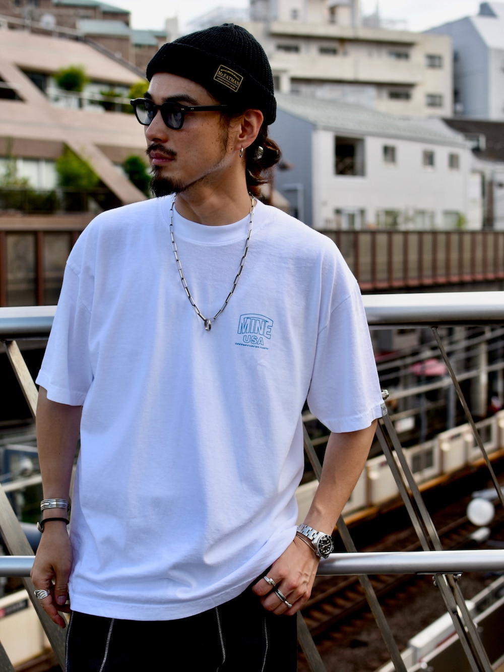 ホワイト系のTシャツ/カットソー、ブラック系のデニムパンツ、ブラック系のスニーカーを着用したメンズの夏コーディネートの2枚目の写真