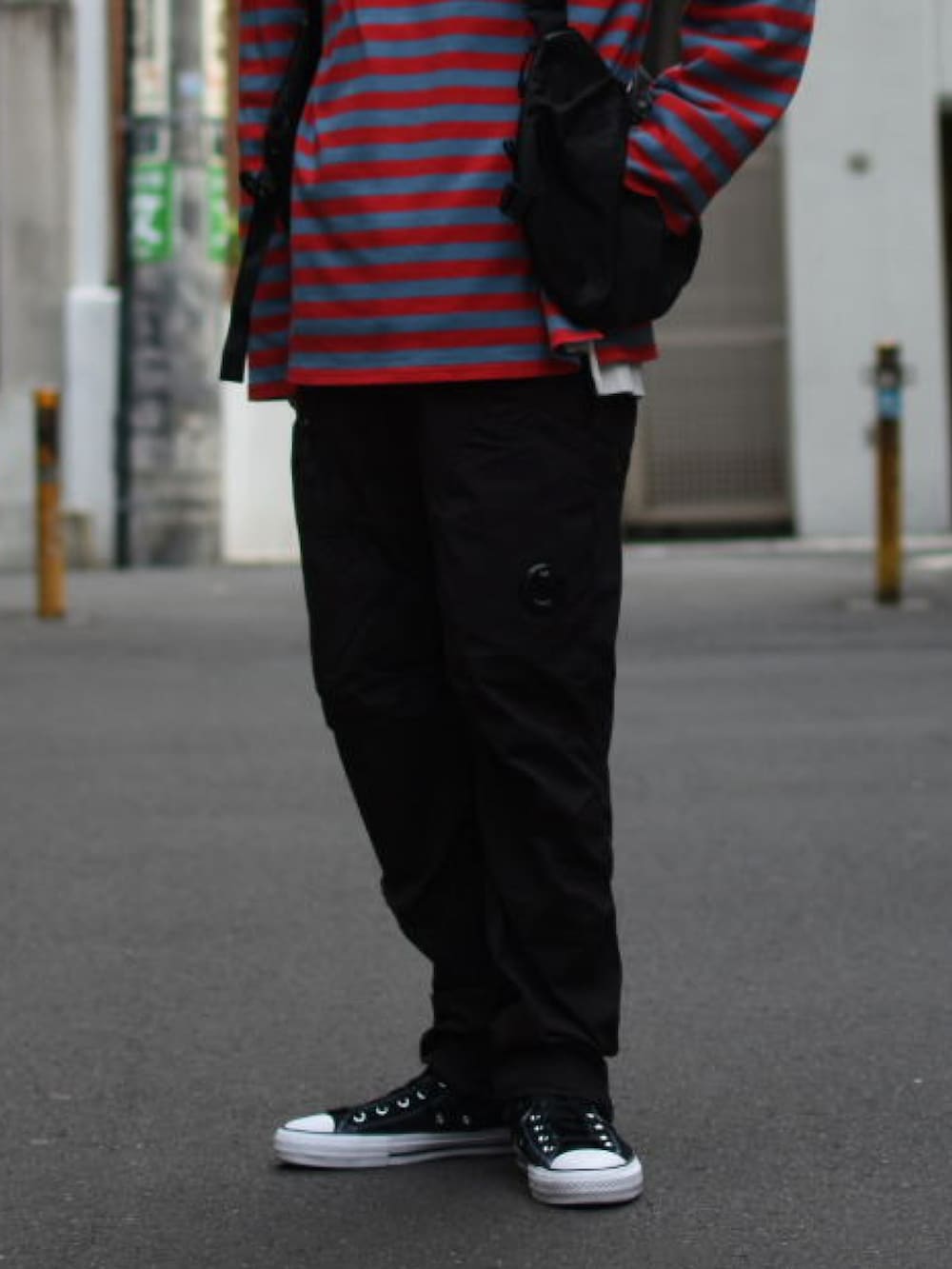 ブラック系のベスト、レッド系のTシャツ/カットソー、ブラック系のカーゴパンツを着用したメンズの春コーディネートの5枚目の写真