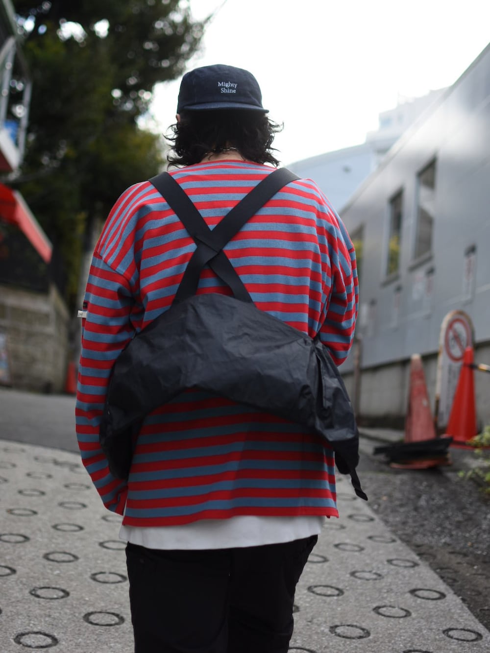 ブラック系のベスト、レッド系のTシャツ/カットソー、ブラック系のカーゴパンツを着用したメンズの春コーディネートの3枚目の写真