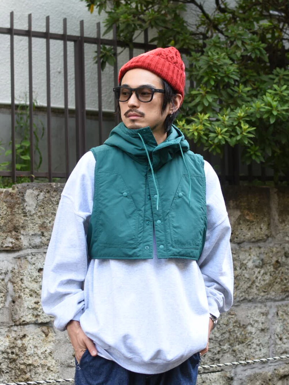 グリーン系のダウンベスト、グレー系のスウェット、ブルー系のパンツを着用したメンズの秋コーディネートの4枚目の写真