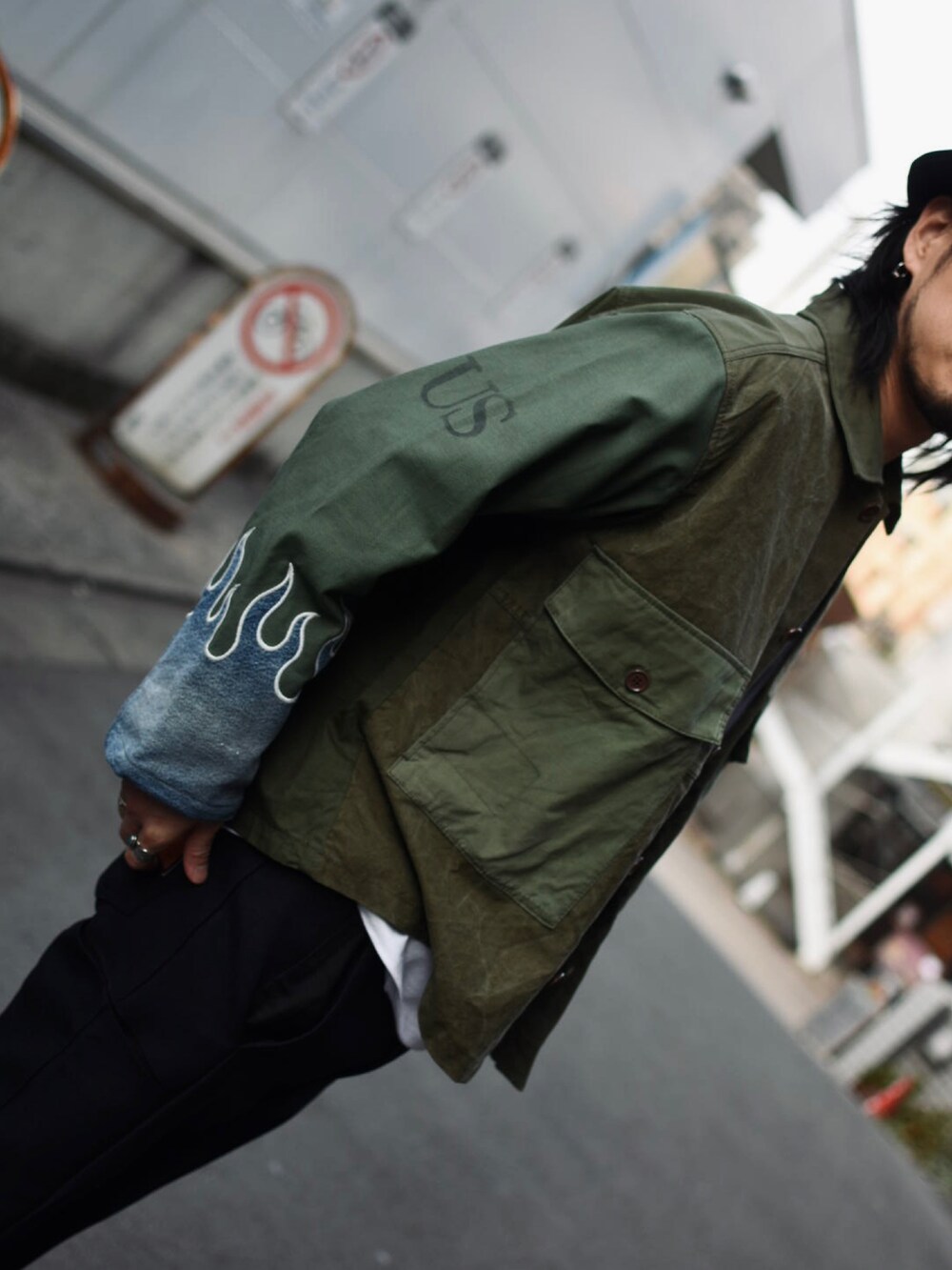 ブラック系のスラックス、グリーン系のミリタリージャケット、ブラック系のその他シューズを着用したメンズの春コーディネートの3枚目の写真