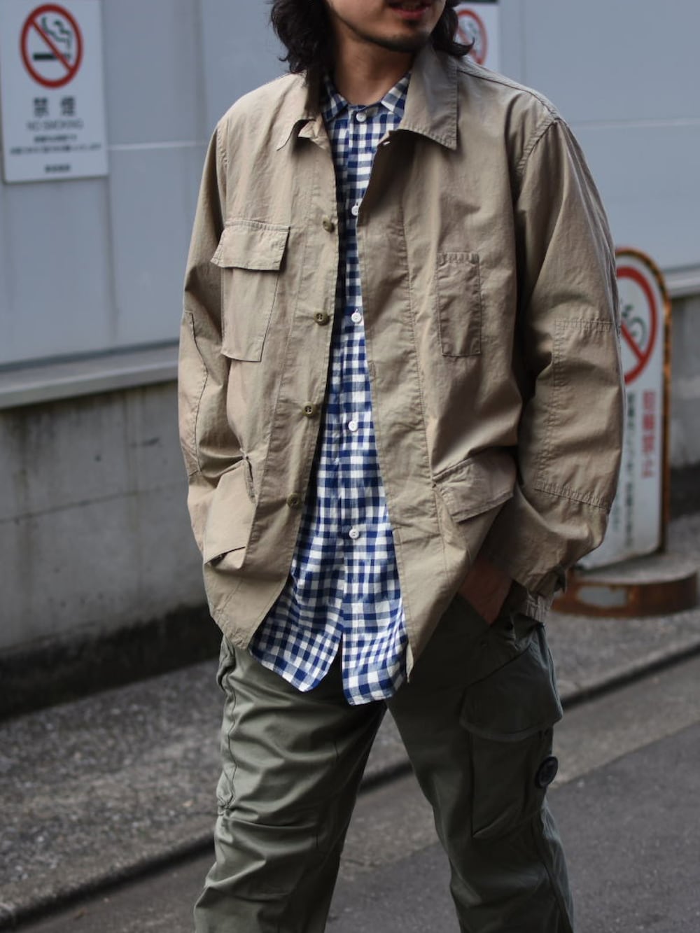 ベージュ系のミリタリージャケット、ブルー系のシャツ/ブラウス、グリーン系のカーゴパンツを着用したメンズの春コーディネートの2枚目の写真