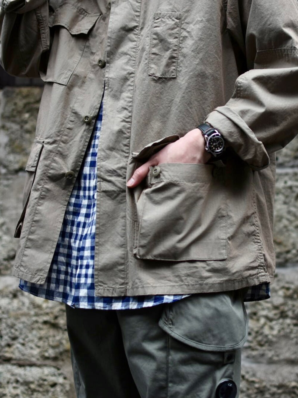 ベージュ系のミリタリージャケット、ブルー系のシャツ/ブラウス、グリーン系のカーゴパンツを着用したメンズの春コーディネートの4枚目の写真