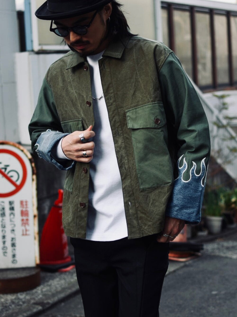 ブラック系のスラックス、グリーン系のミリタリージャケット、ブラック系のその他シューズを着用したメンズの春コーディネートの2枚目の写真