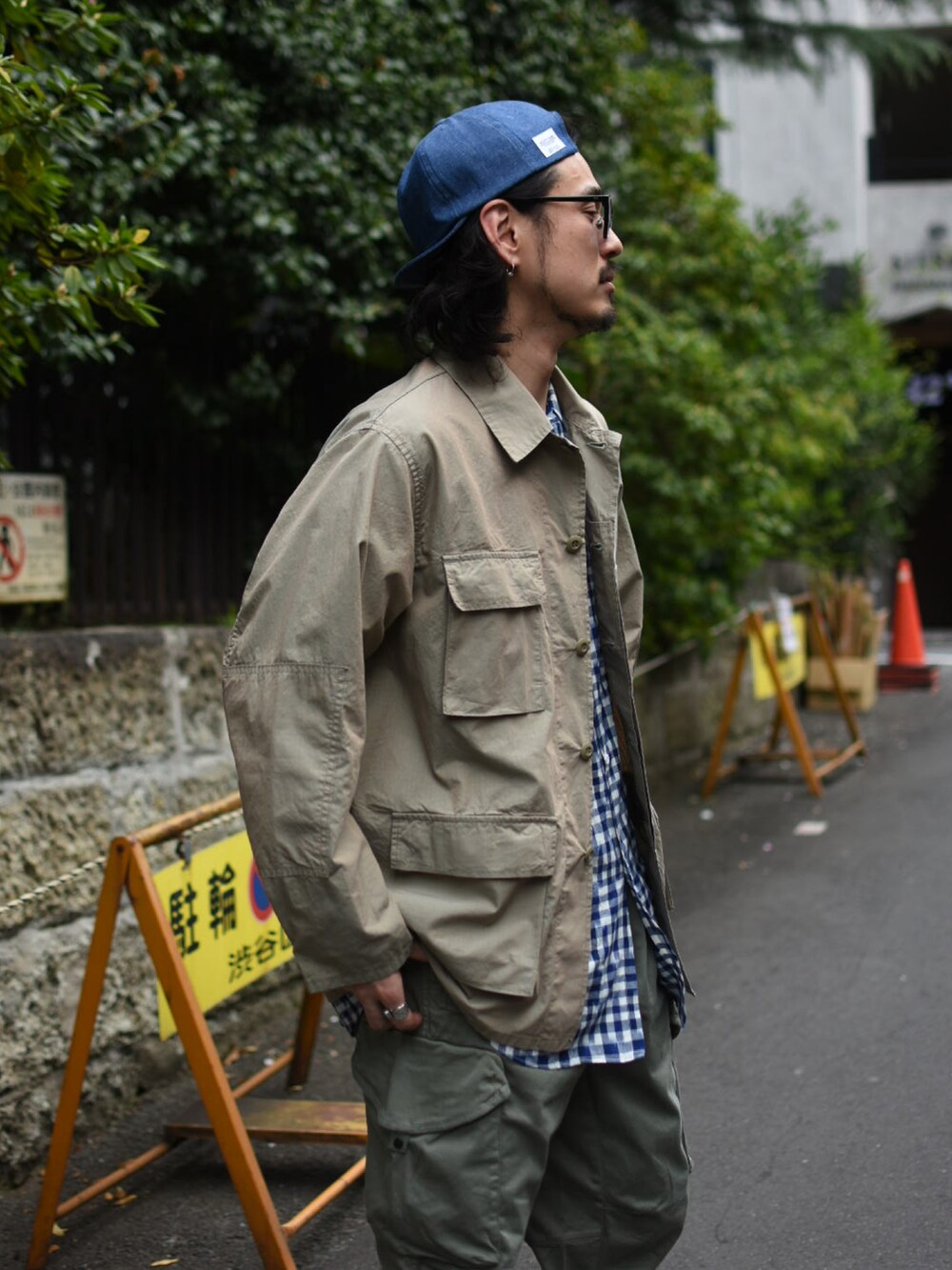 ベージュ系のミリタリージャケット、ブルー系のシャツ/ブラウス、グリーン系のカーゴパンツを着用したメンズの春コーディネートの3枚目の写真