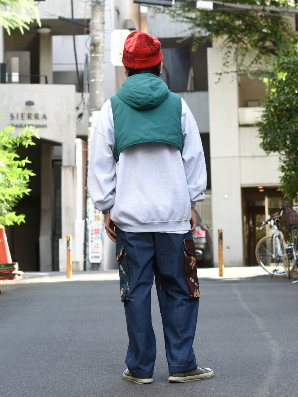 グリーン系のダウンベスト、グレー系のスウェット、ブルー系のパンツを着用したメンズの秋コーディネートの3枚目の写真