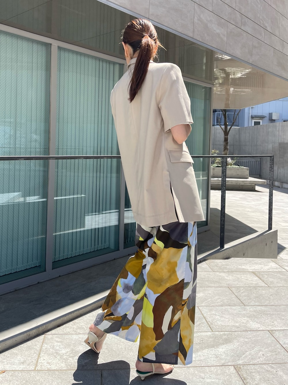 ベージュ系のジャケット/アウター、ホワイト系のニット/セーター、イエロー系のパンツを着用したレディースの春コーディネートの2枚目の写真