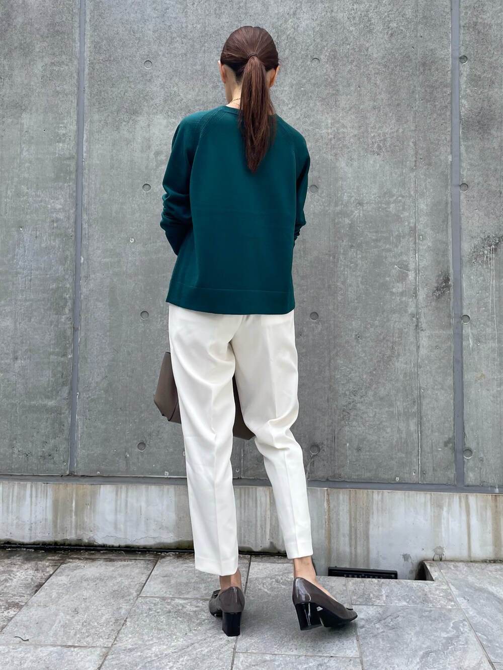 グリーン系のニット/セーター、ホワイト系のパンツ、グリーン系のニット/セーターを着用したレディースの秋コーディネートの2枚目の写真