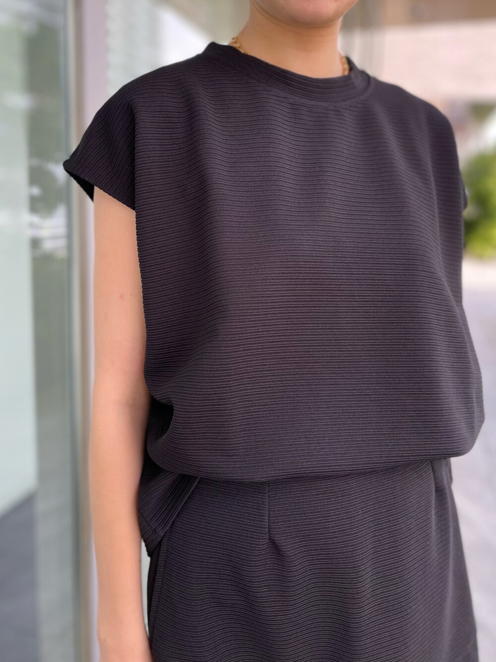 ブラック系のTシャツ/カットソー、ブラック系のスカート、ブラック系のアンサンブルを着用したレディースの夏コーディネートの2枚目の写真