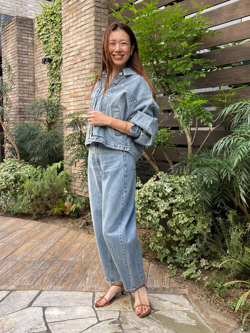 ブルー系のデニムジャケット、ブルー系のデニムパンツ、ブルー系のデニムジャケットを着用したレディースの秋コーディネートの2枚目の写真