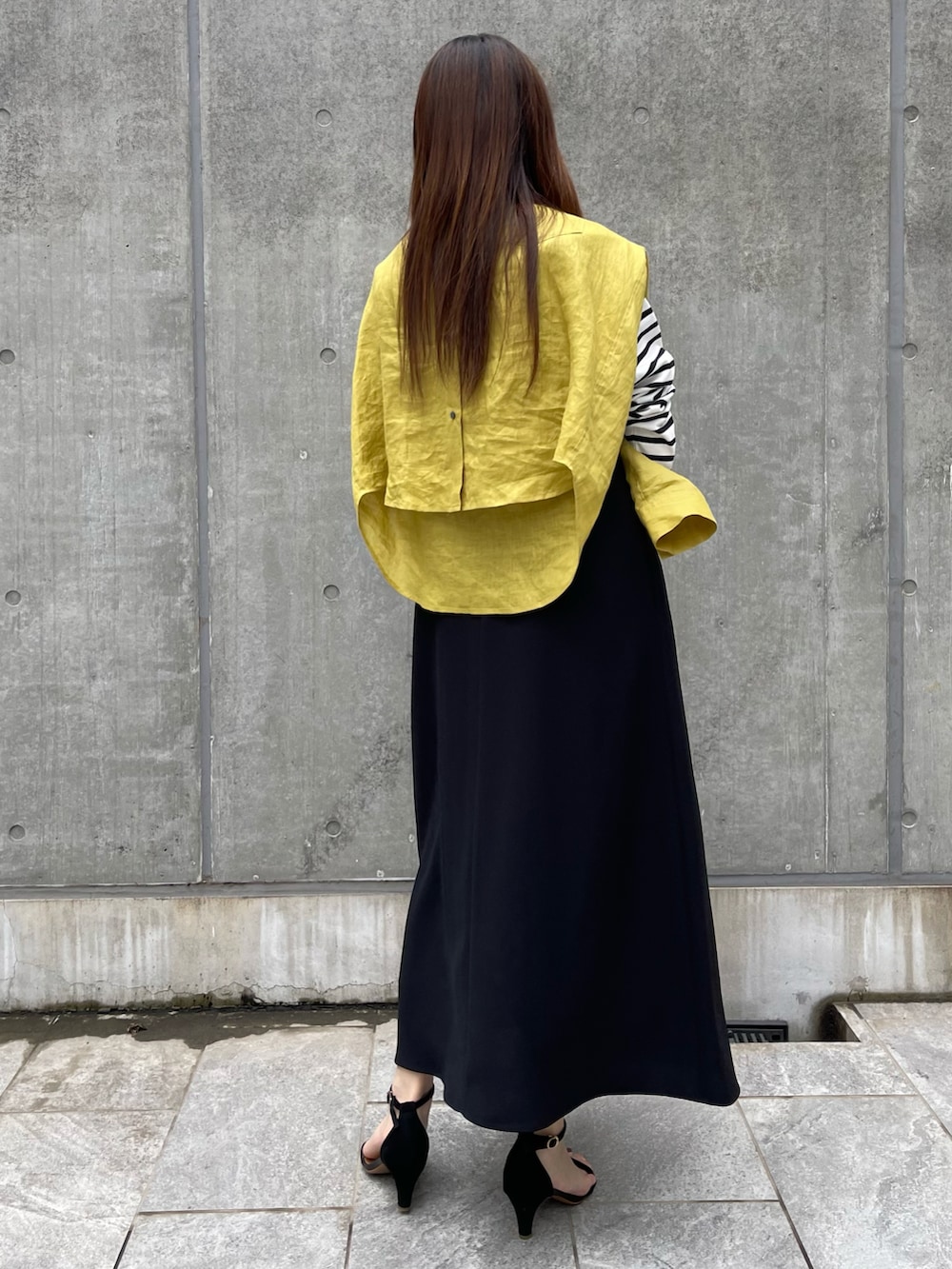 イエロー系のシャツ/ブラウス、ブラック系のTシャツ/カットソー、ブラック系のワンピースを着用したレディースの春コーディネートの2枚目の写真