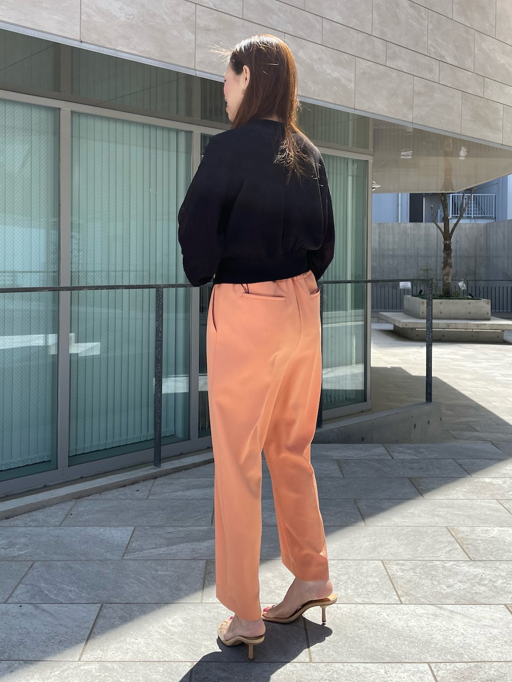 オレンジ系のパンツ、ブラック系のカーディガン/ボレロ、ブラック系のカーディガン/ボレロを着用したレディースの春コーディネートの2枚目の写真