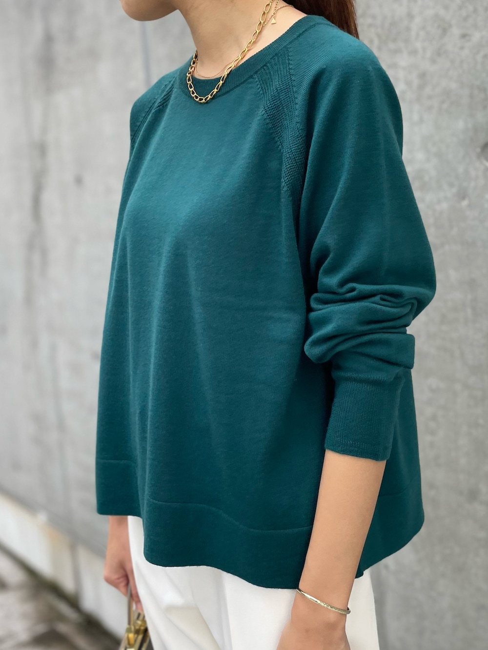 グリーン系のニット/セーター、ホワイト系のパンツ、グリーン系のニット/セーターを着用したレディースの秋コーディネートの3枚目の写真