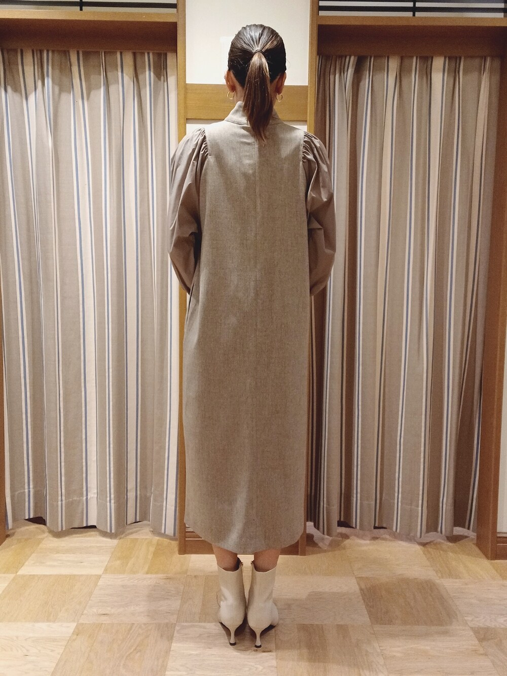 ベージュ系のワンピースを着用したレディースの秋コーディネートの4枚目の写真