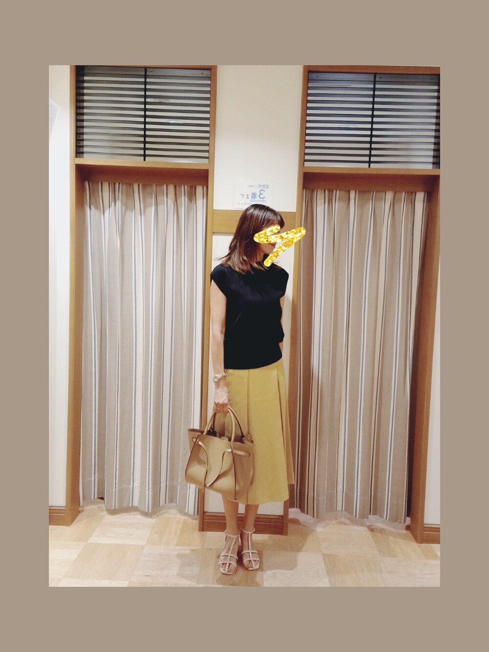 ブラック系のニット/セーター、イエロー系のスカート、ホワイト系のサンダルを着用したレディースの夏コーディネートの2枚目の写真