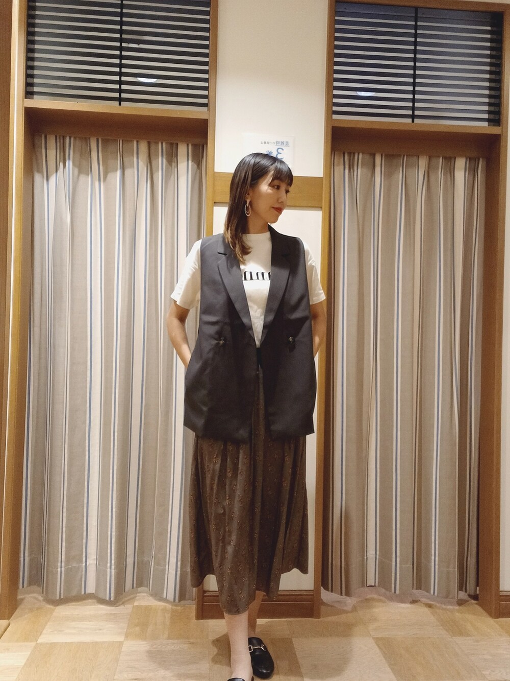 ホワイト系のTシャツ/カットソー、グレー系のノーカラージャケット、グリーン系のスカートを着用したレディースの秋コーディネートの2枚目の写真