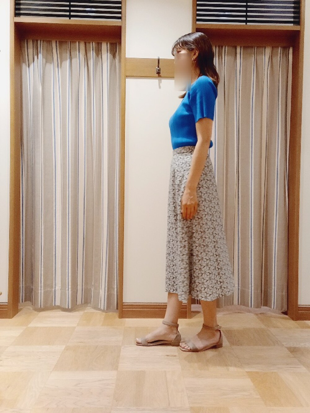 ブルー系のニット/セーター、ブラック系のスカートを着用したレディースの夏コーディネートの3枚目の写真