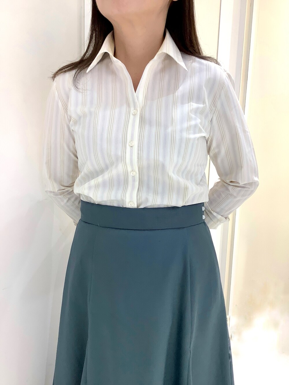 イエロー系のビジネスシャツを着用したレディースの春コーディネートの2枚目の写真