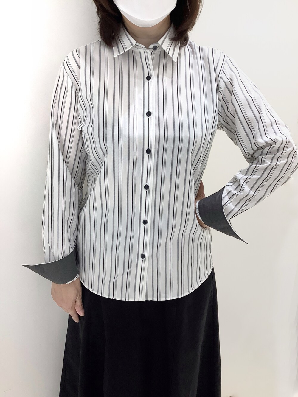 グレー系のビジネスシャツを着用したレディースの秋コーディネートの2枚目の写真