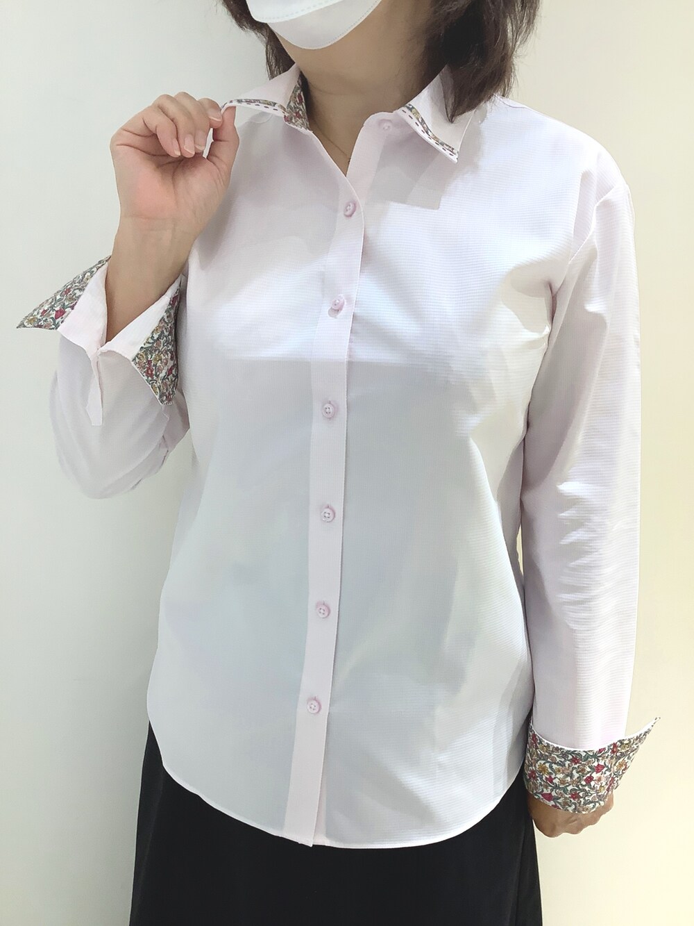 ピンク系のビジネスシャツを着用したレディースの秋コーディネートの2枚目の写真