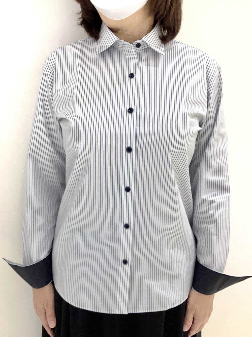 ブルー系のビジネスシャツを着用したレディースの秋コーディネートの2枚目の写真