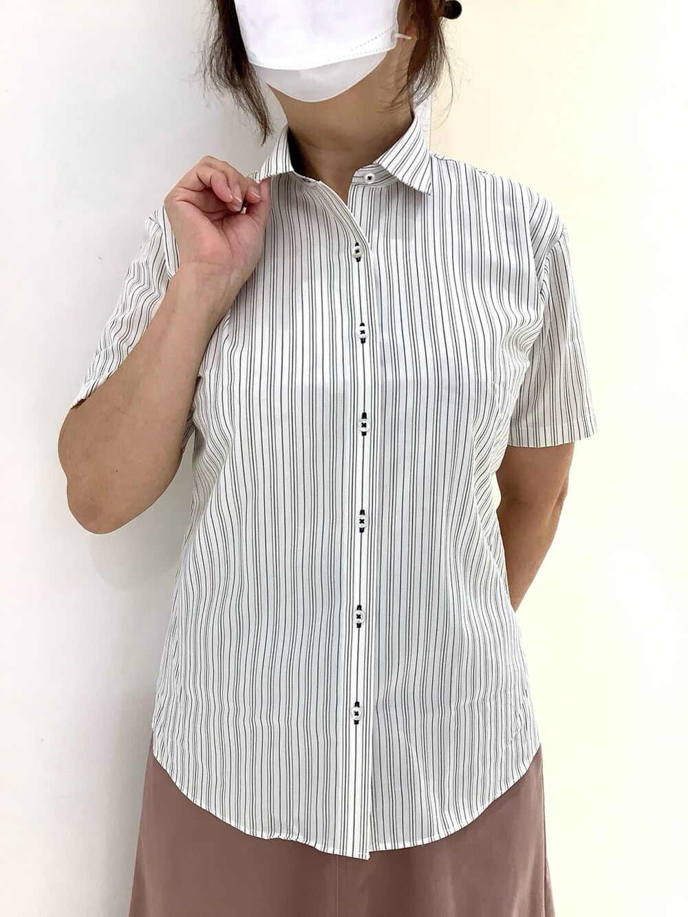 イエロー系のビジネスシャツを着用したレディースの夏コーディネートの2枚目の写真