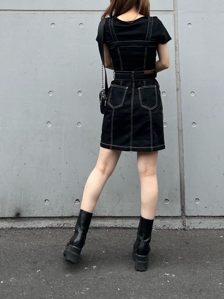 ブラック系のブーツ、ブラック系のジャンパースカート、ブラック系のTシャツ/カットソーを着用したレディースの夏コーディネートの2枚目の写真