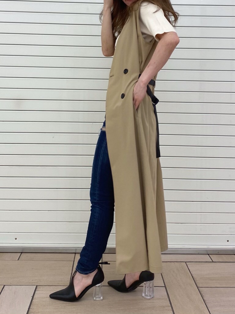 ベージュ系のトレンチコート、ブラック系のパンプス、ホワイト系のTシャツ/カットソーを着用したレディースの春コーディネートの2枚目の写真