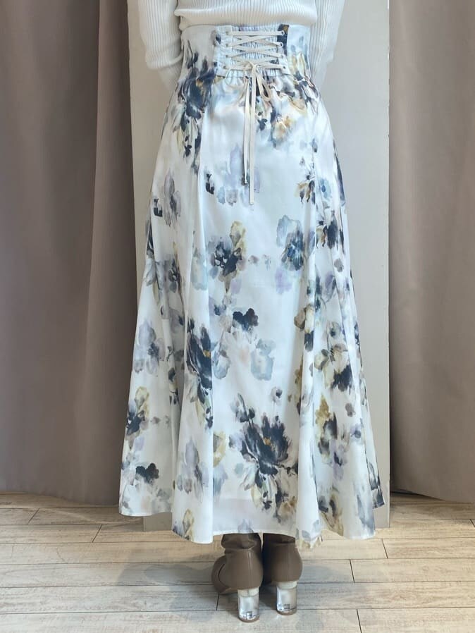 ホワイト系のスカート、ホワイト系のニット/セーター、ブラウン系のダウンジャケット/コートを着用したレディースの秋コーディネートの10枚目の写真