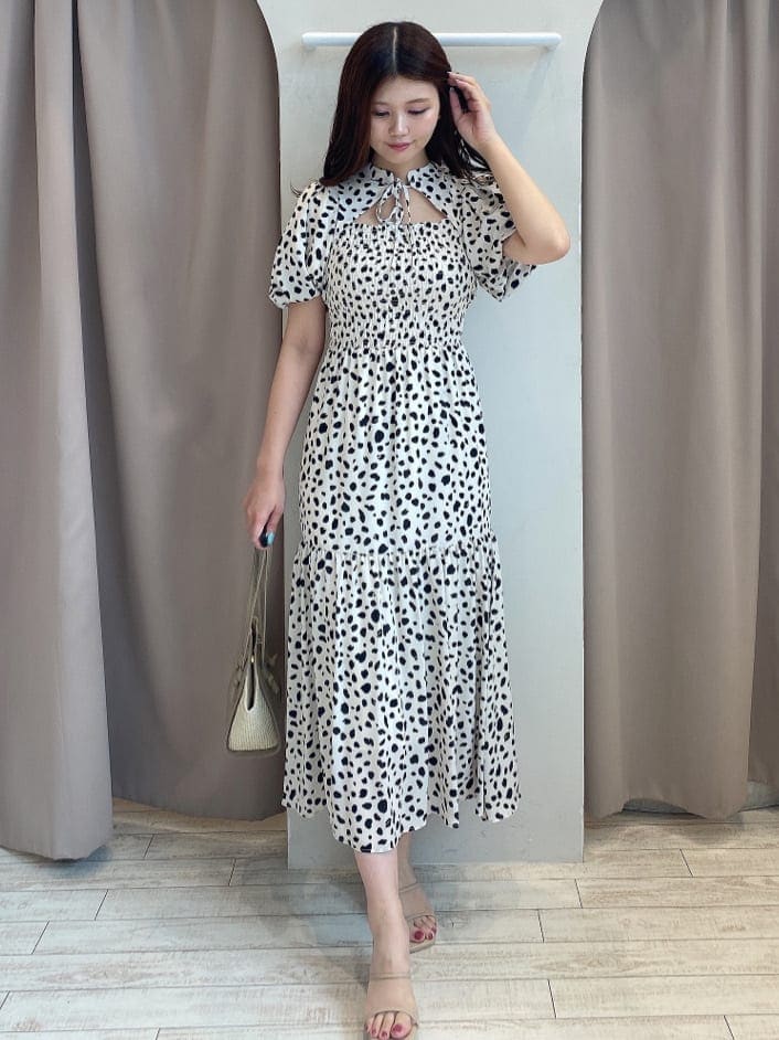 ベージュ系のトートバッグ、ベージュ系のサンダル、ホワイト系のワンピースを着用したレディースの夏コーディネートの2枚目の写真