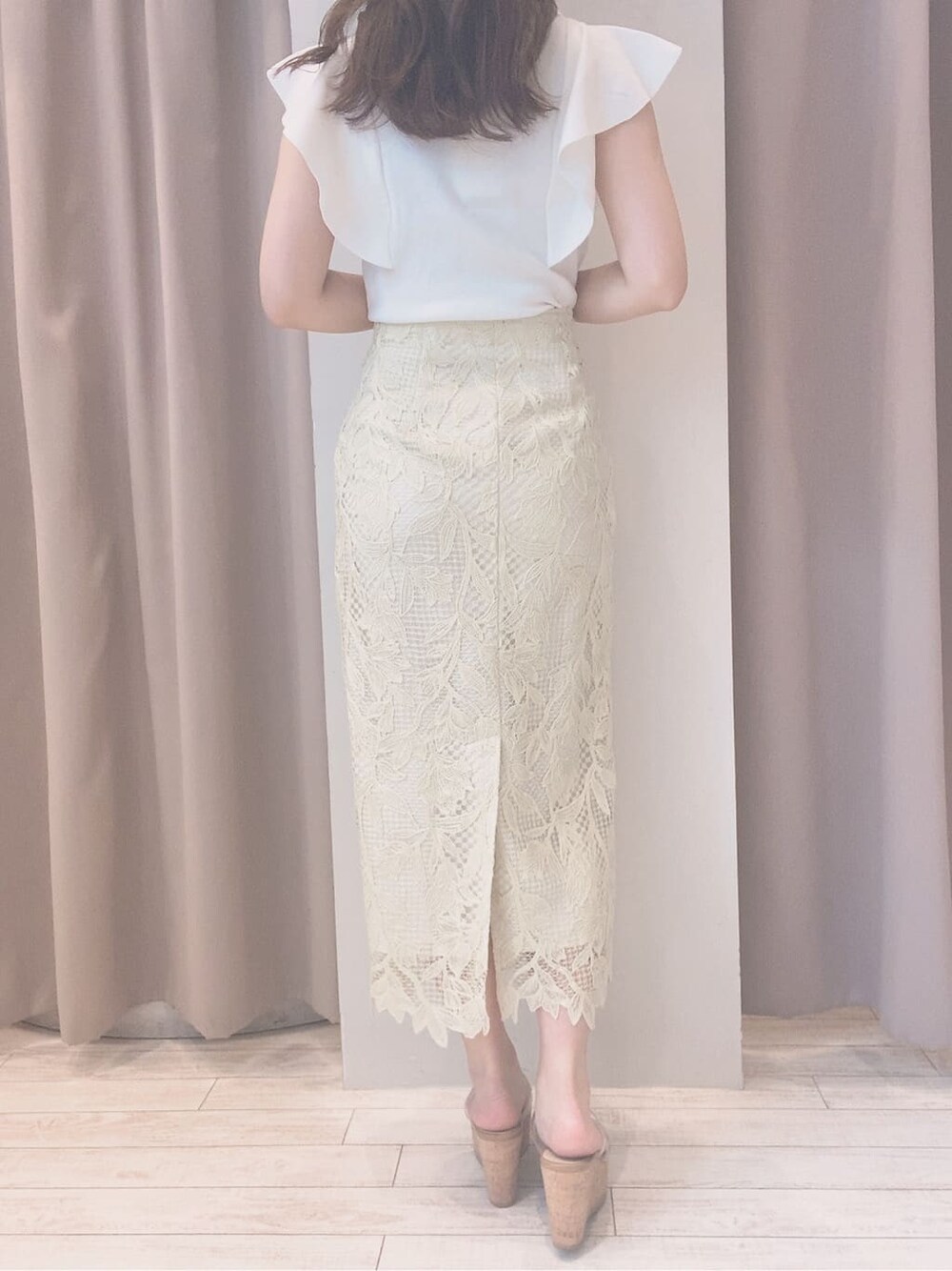 イエロー系のスカート、ホワイト系のニット/セーター、その他のサンダルを着用したレディースの春コーディネートの6枚目の写真