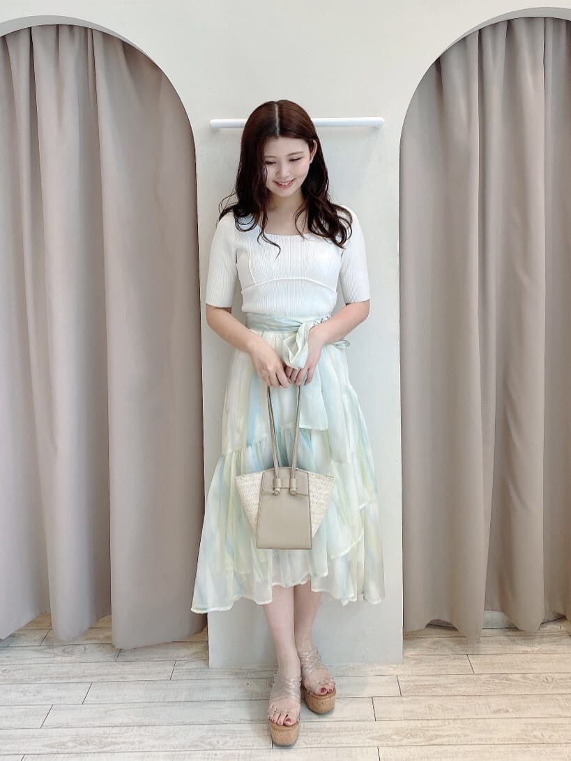 グリーン系のスカート、その他のサンダル、ベージュ系のトートバッグを着用したレディースの春コーディネートの2枚目の写真