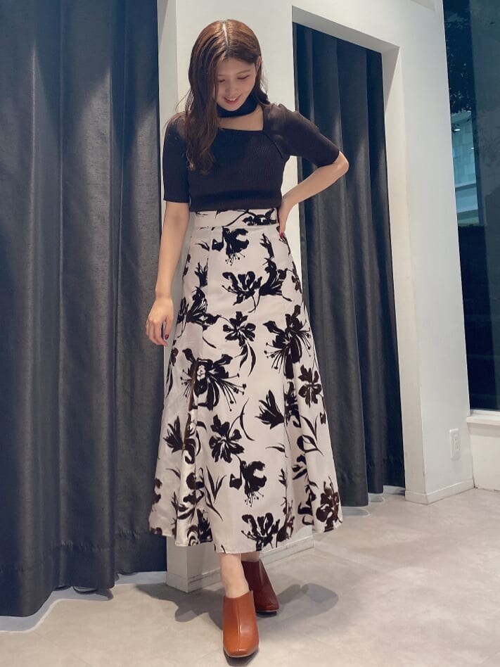 ブラウン系のサンダル、ブラウン系のニット/セーター、ホワイト系のスカートを着用したレディースの夏コーディネートの2枚目の写真