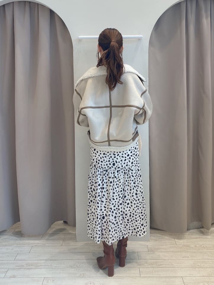 ブラウン系のブーツ、ベージュ系のムートンコート、ホワイト系のワンピースを着用したレディースの夏コーディネートの4枚目の写真