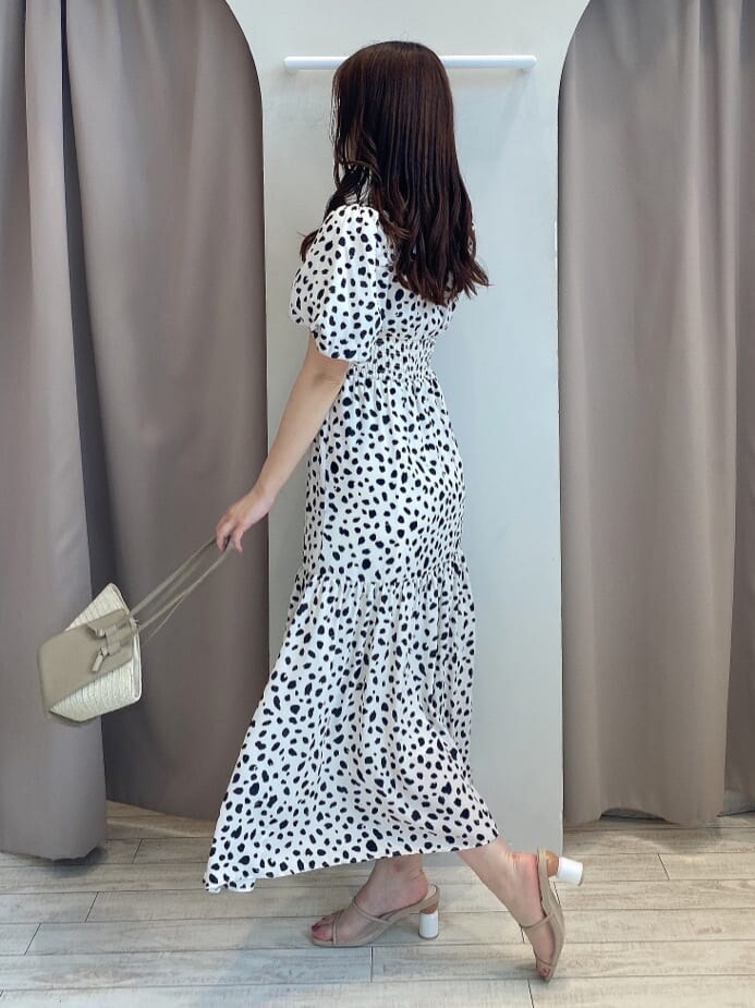 ベージュ系のトートバッグ、ベージュ系のサンダル、ホワイト系のワンピースを着用したレディースの夏コーディネートの3枚目の写真